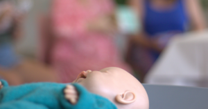 Boneco de treino para demonstração de cuidados ao bebé durante uma sessão de curso de preparação para o parto