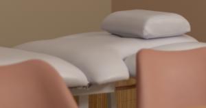 Mesa de tratamento acolchoada num consultório de fisioterapia, com almofada para conforto e ambiente suave e acolhedor