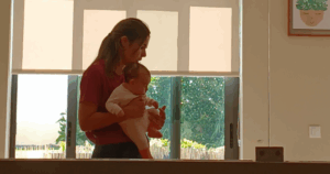 Mãe segura o bebé durante sessão de Pilates Clínico num ambiente acolhedor