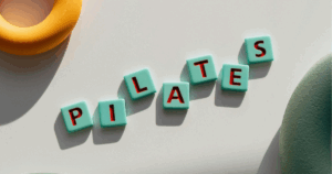 Peças coloridas com letras a formar a palavra “Pilates” sobre fundo claro