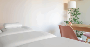 Gabinete de fisioterapia com marquesa, cadeira e ambiente acolhedor